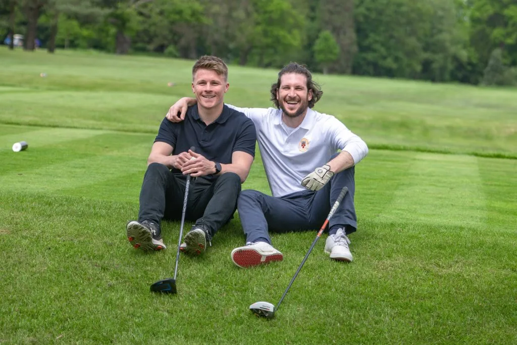 two golfers smiling next to each other at a golf course in nottingham