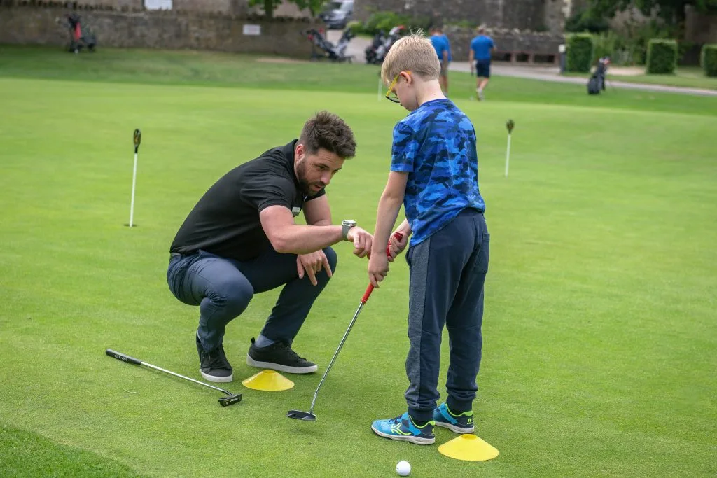 golf coach helping a young boy with putting, using cones during a golf lesson in calverton