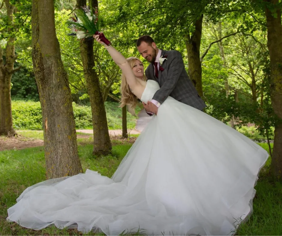 newly wed couple posing for a photo in a woodland area at a wedding venue near nottingham